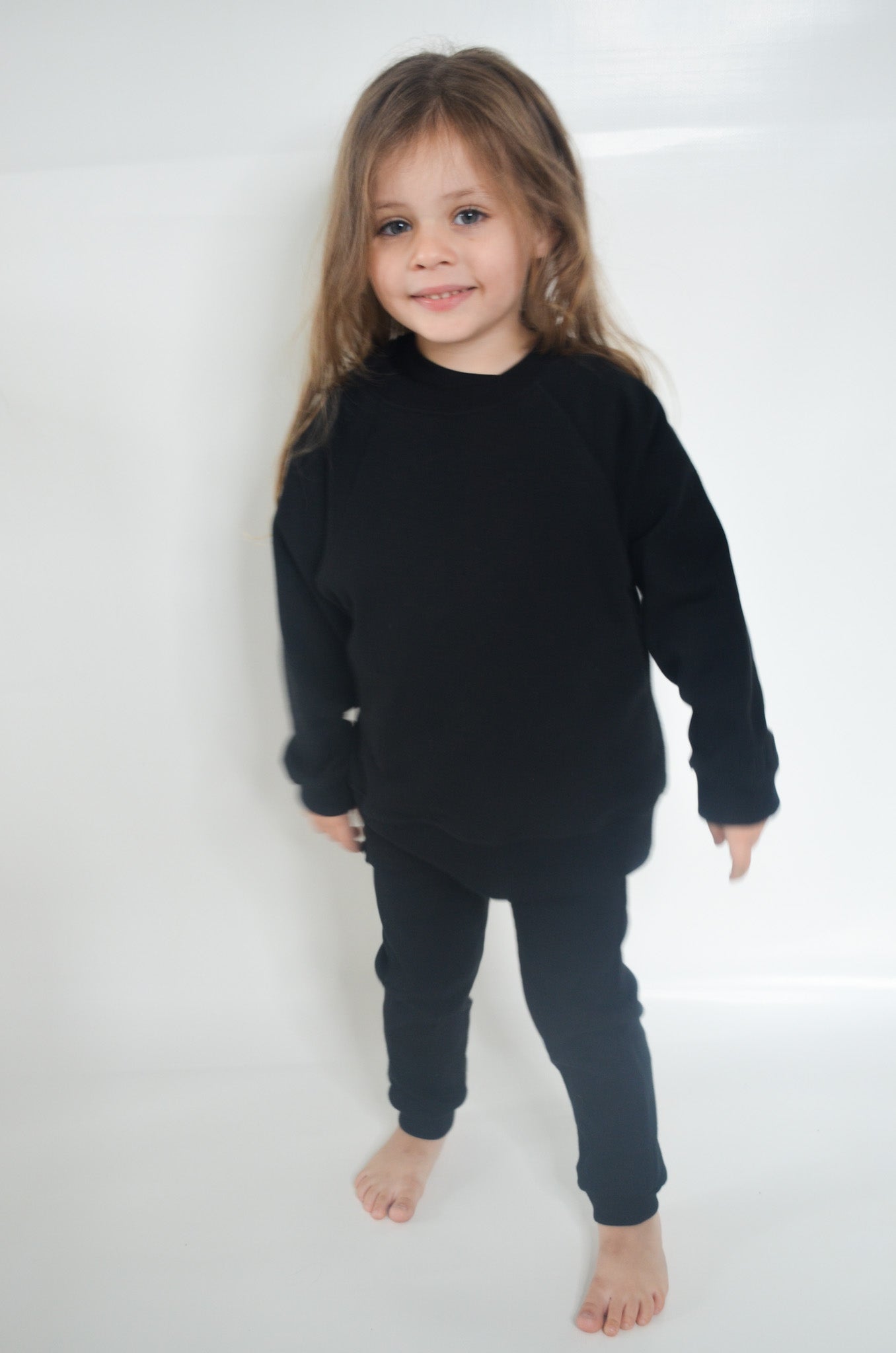 Girl wearing black legging, black batwing jumper