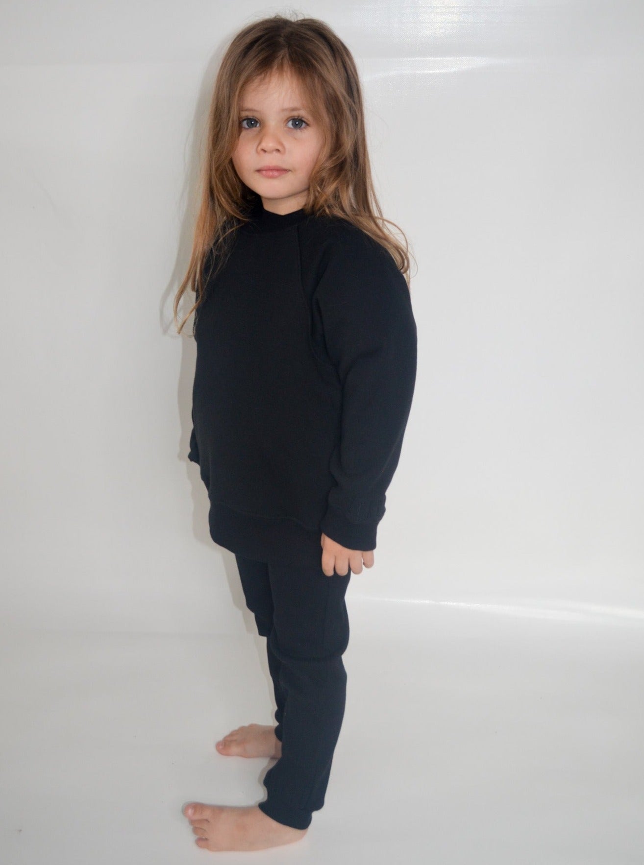 Girl wearing black colour batwing jumper with black longline t-shirt and black colour trackpants
