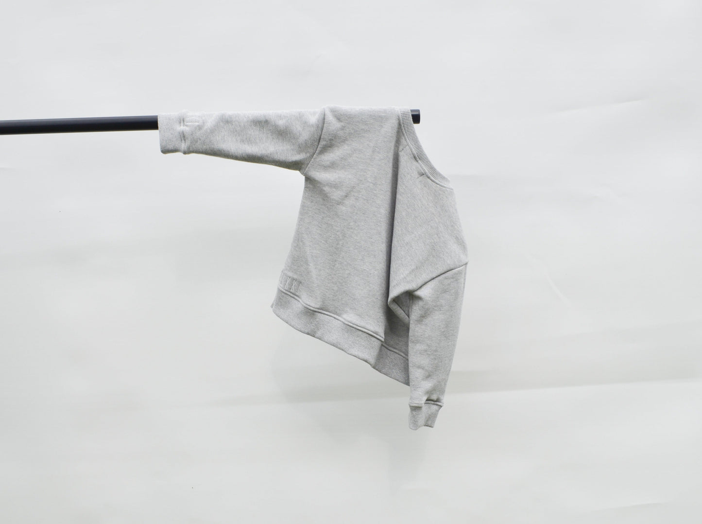 back of Grey longline jumper hanging on a pole