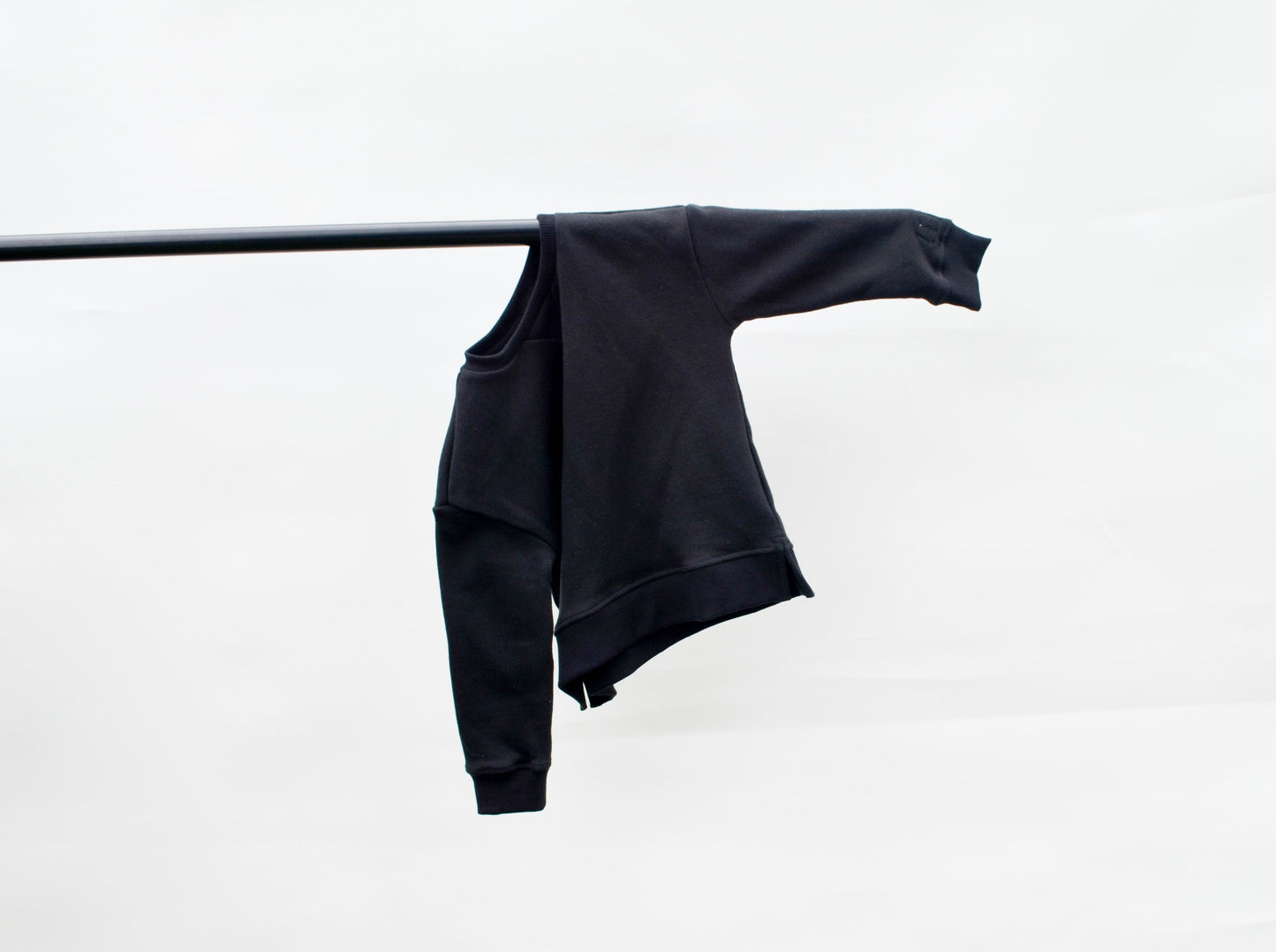 Black longline jumper hanging on a pole