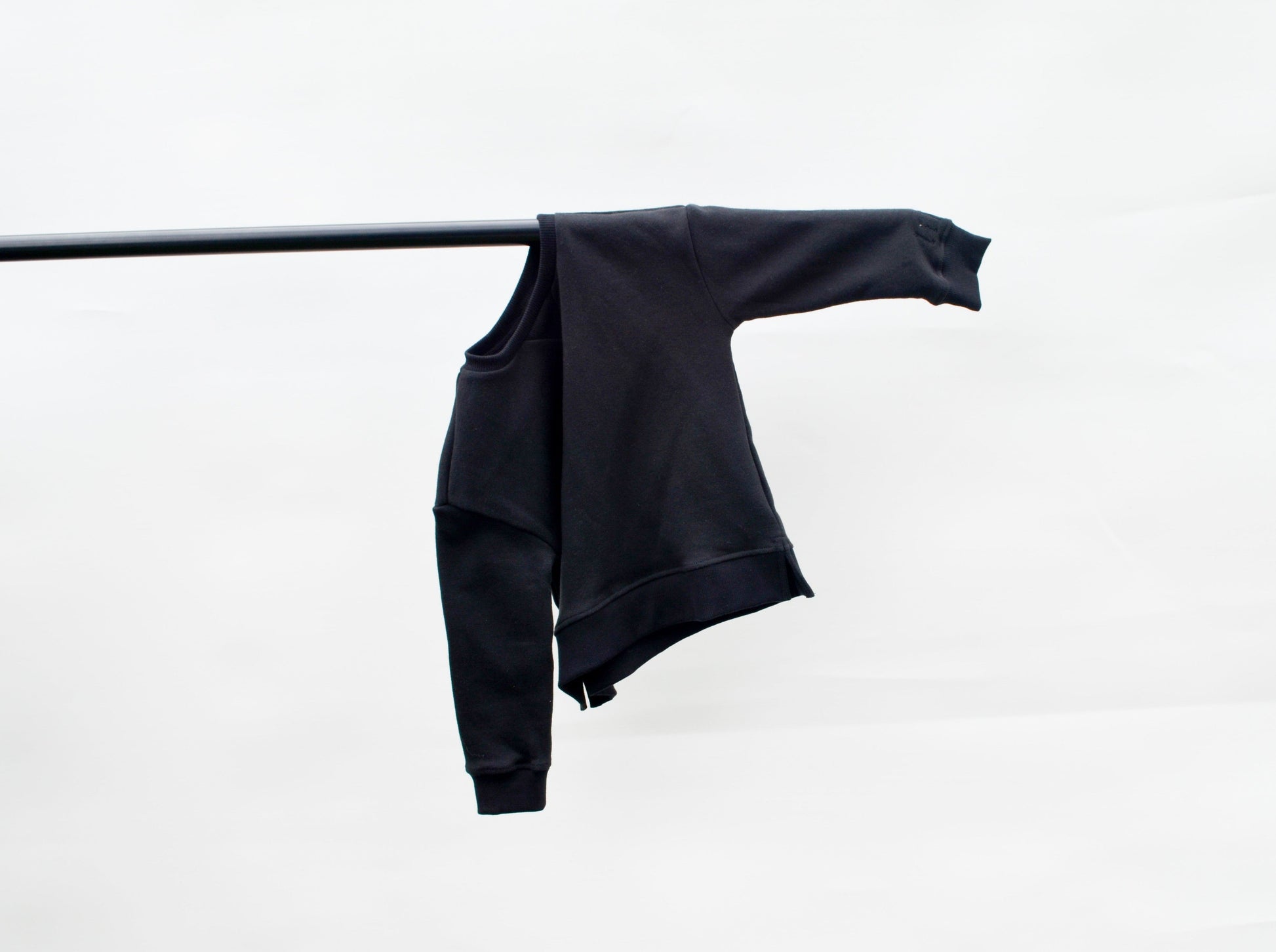 Black longline jumper hanging on a pole