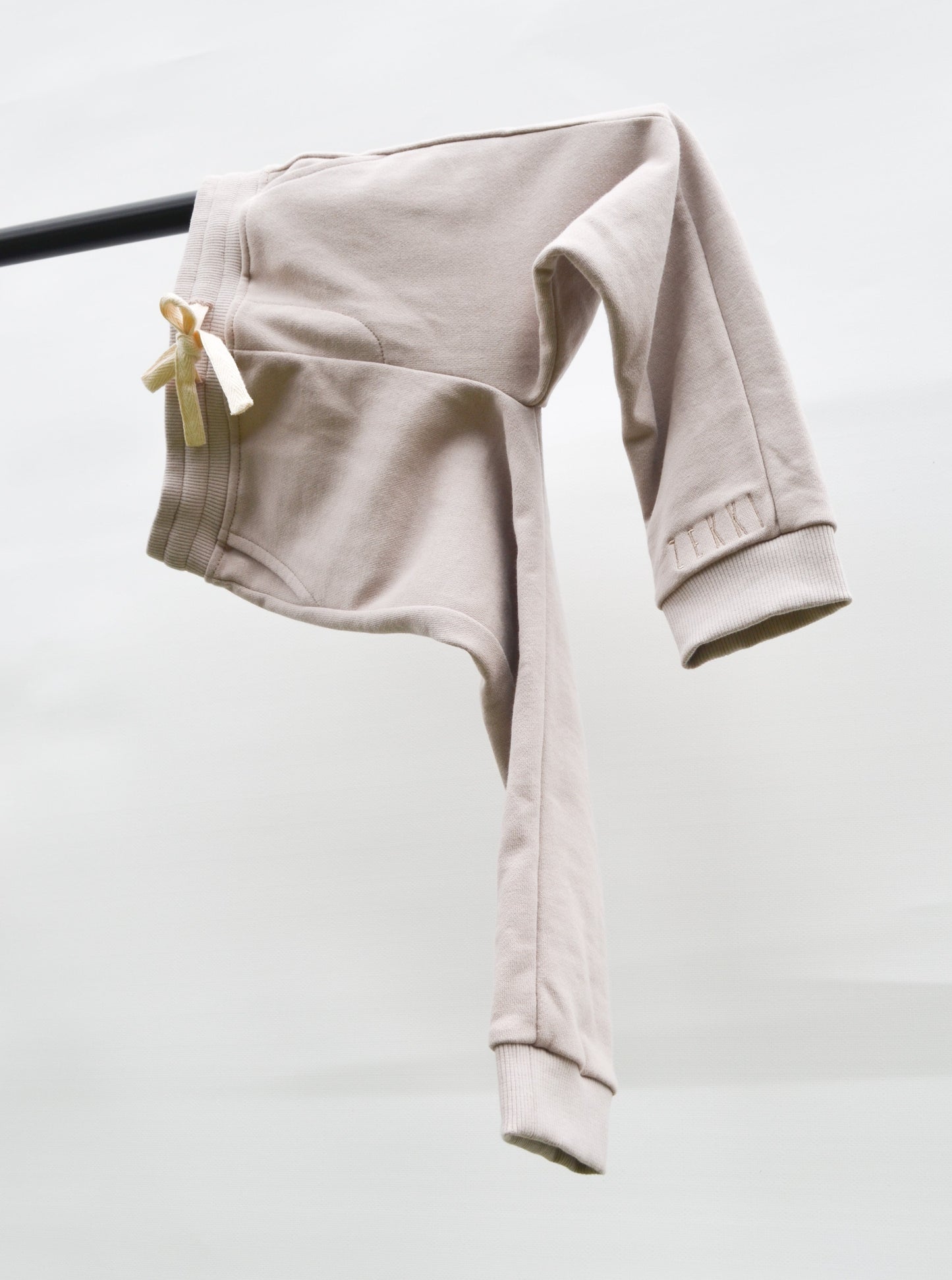 Smokey colour track pants hanging over bar