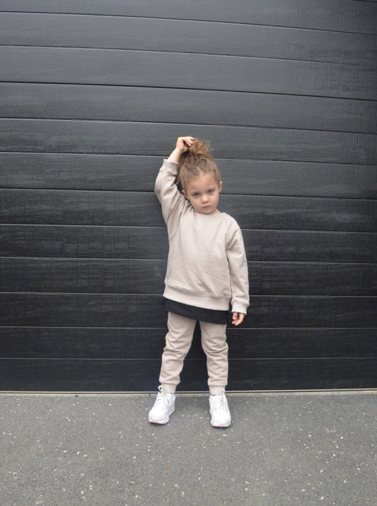Girl wearing smokey colour batwing jumper with black longline t-shirt and smokey colour trackpants.