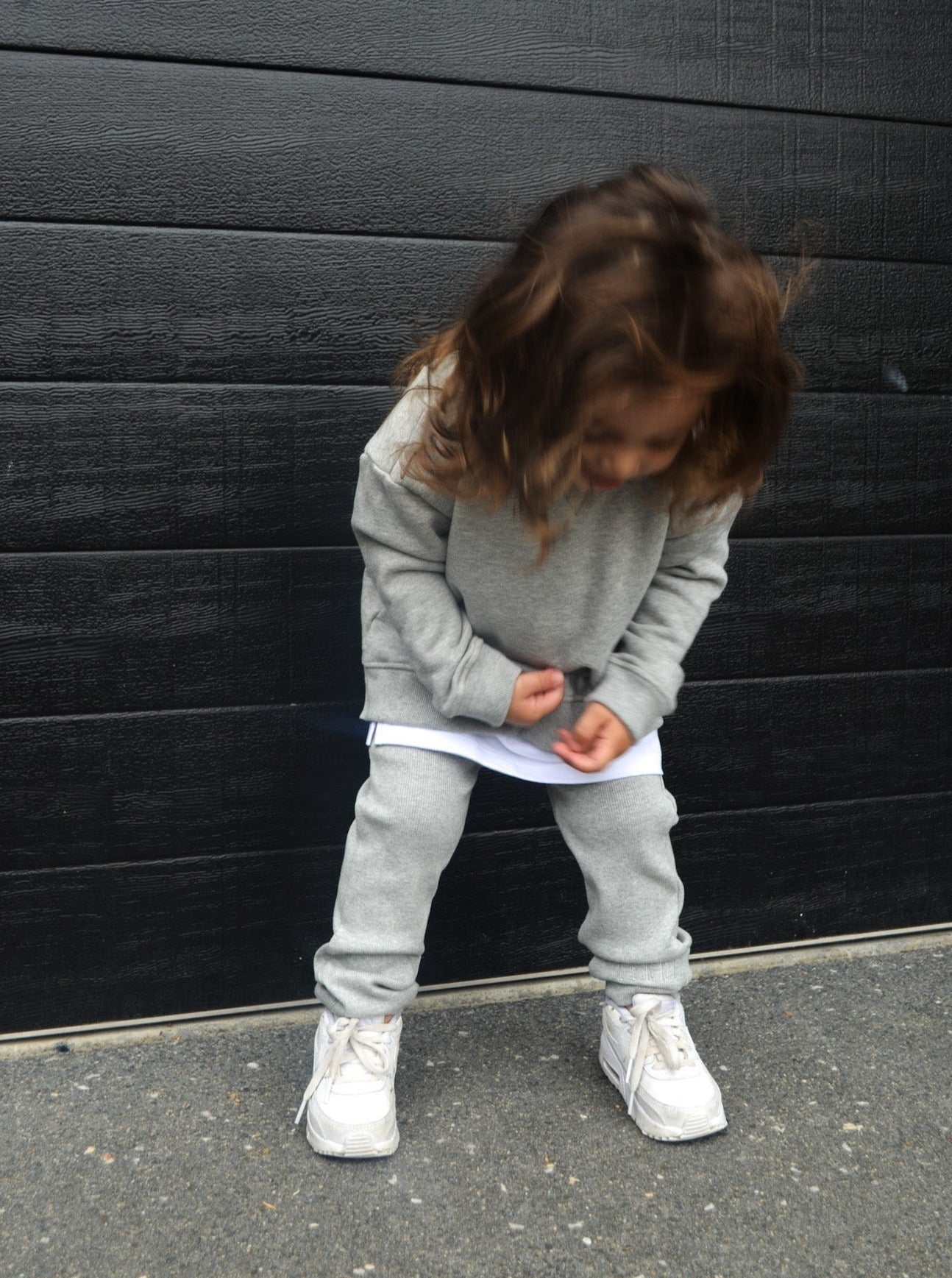 Boy wearing grey legging, longline jumper and a white t-shirt