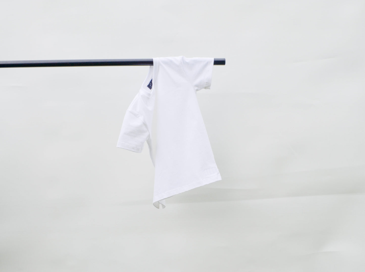 White colour t-shirt hanging over pole