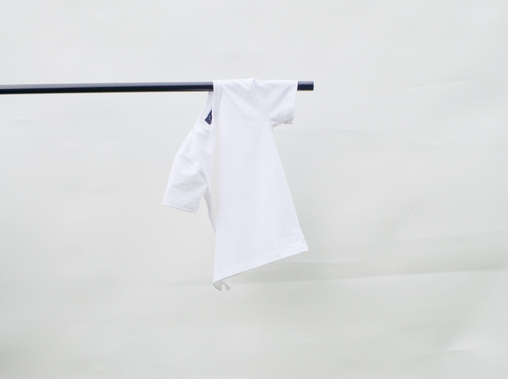 White colour t-shirt hanging over pole