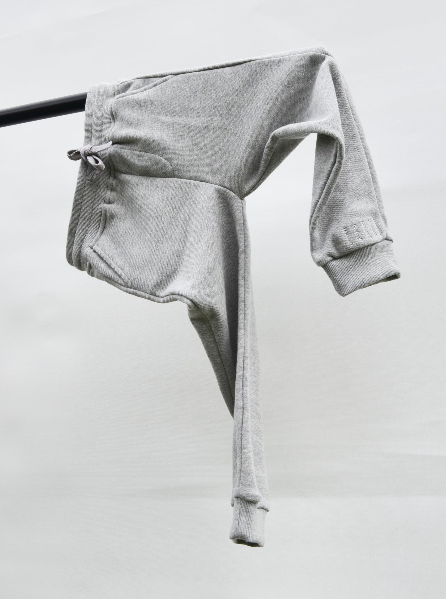 Grey colour track pants hanging over bar