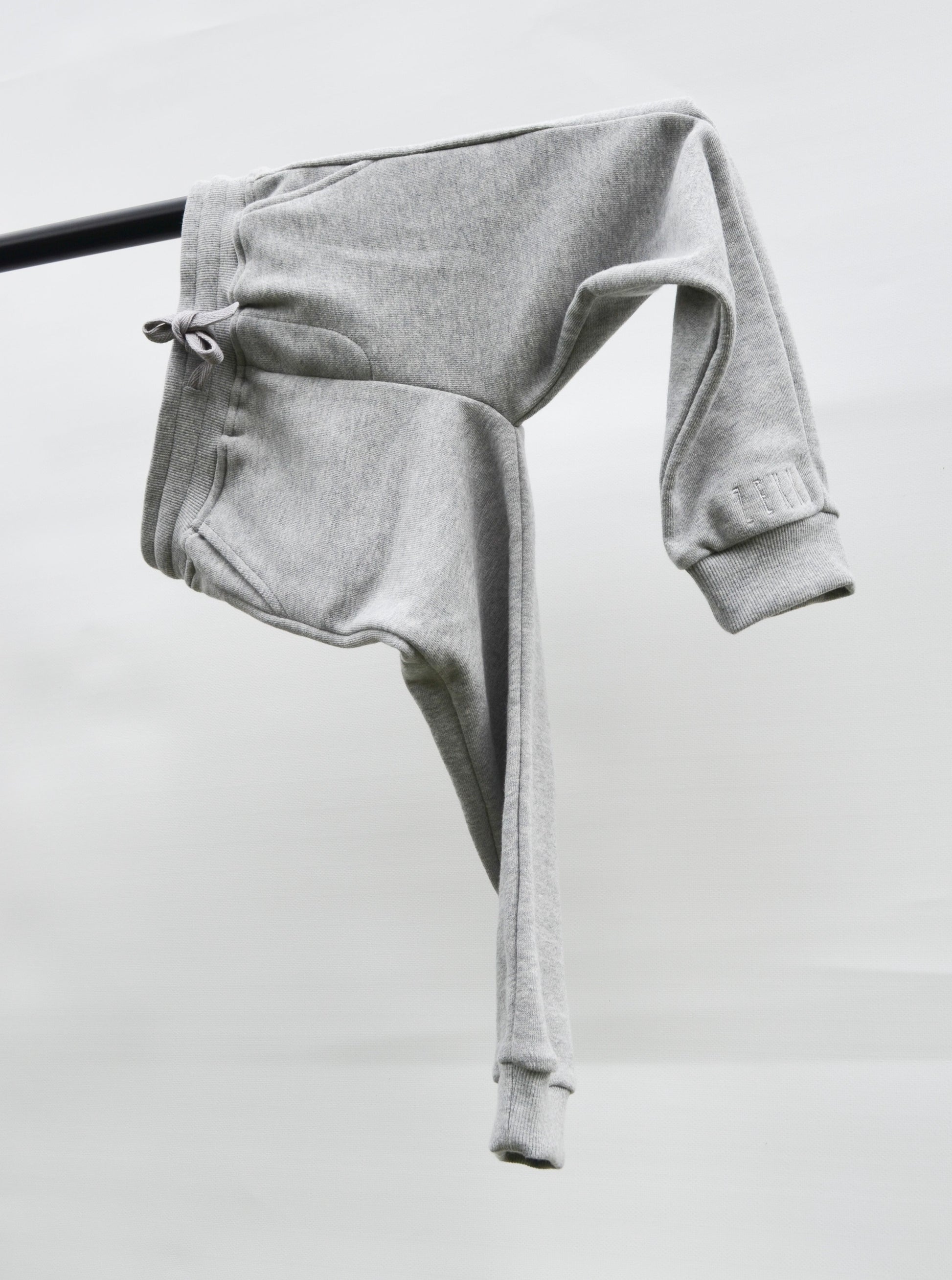 Grey colour track pants hanging over bar