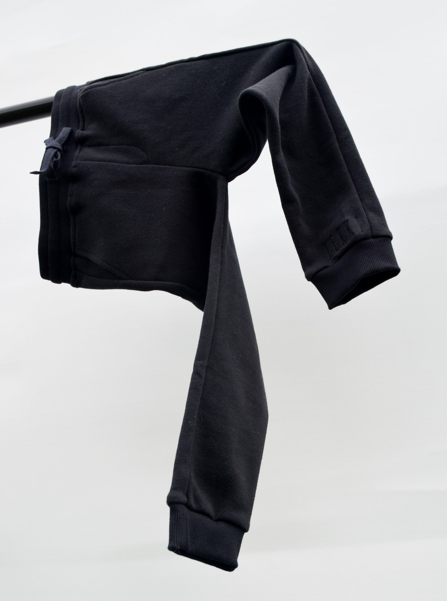 Black colour track pants hanging over bar