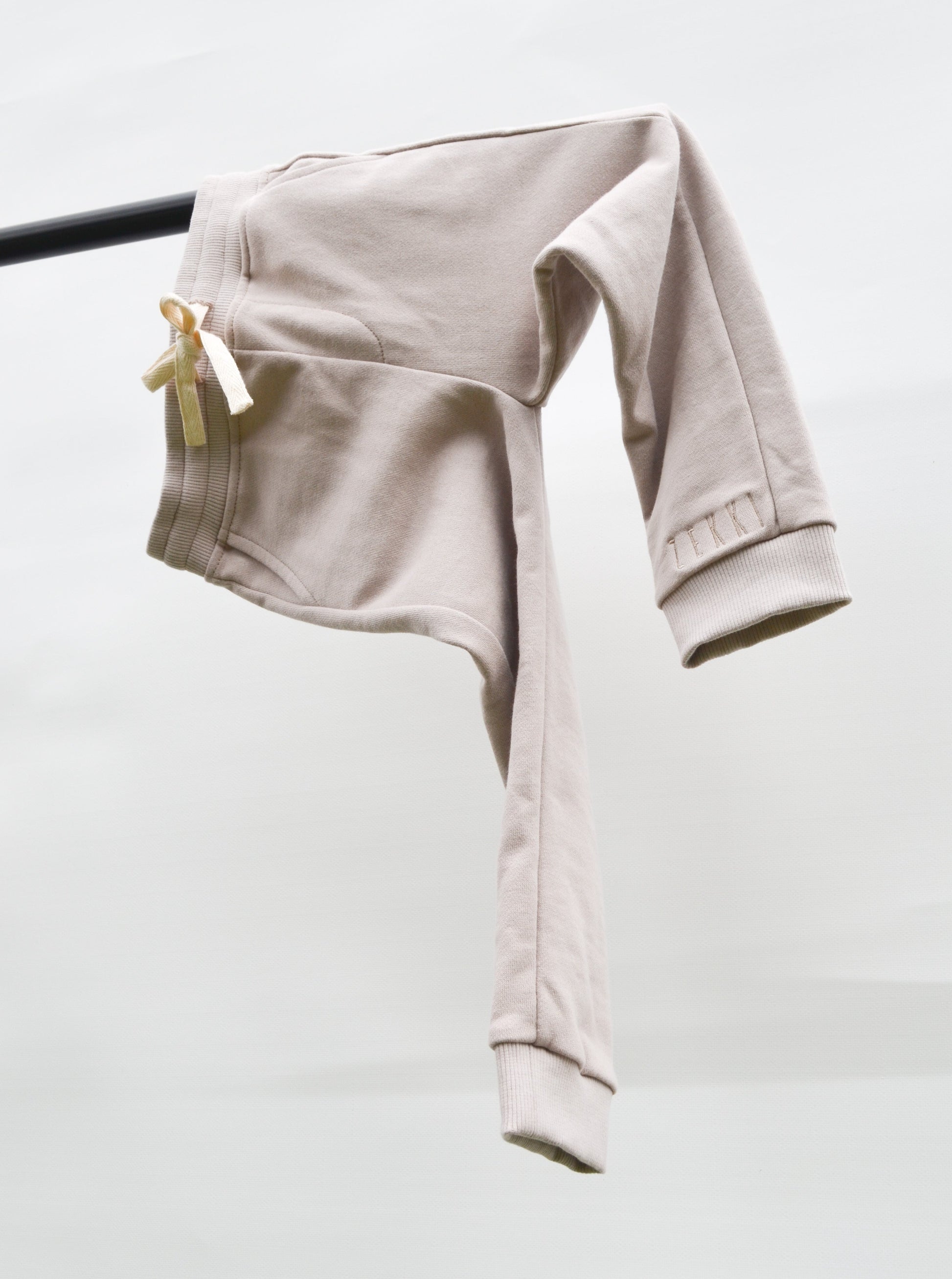 Smokey colour track pants hanging over bar
