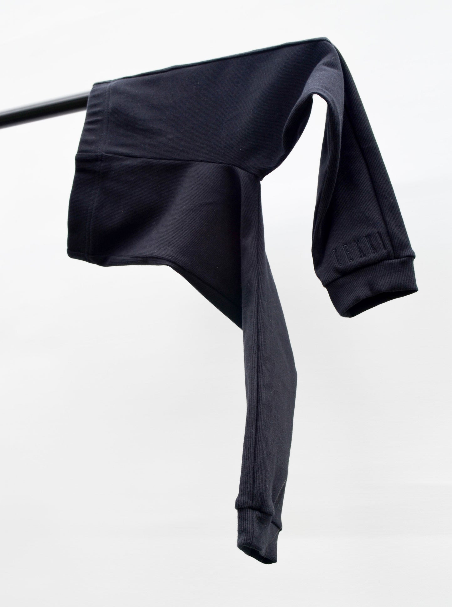 Black casual pants hanging over pole