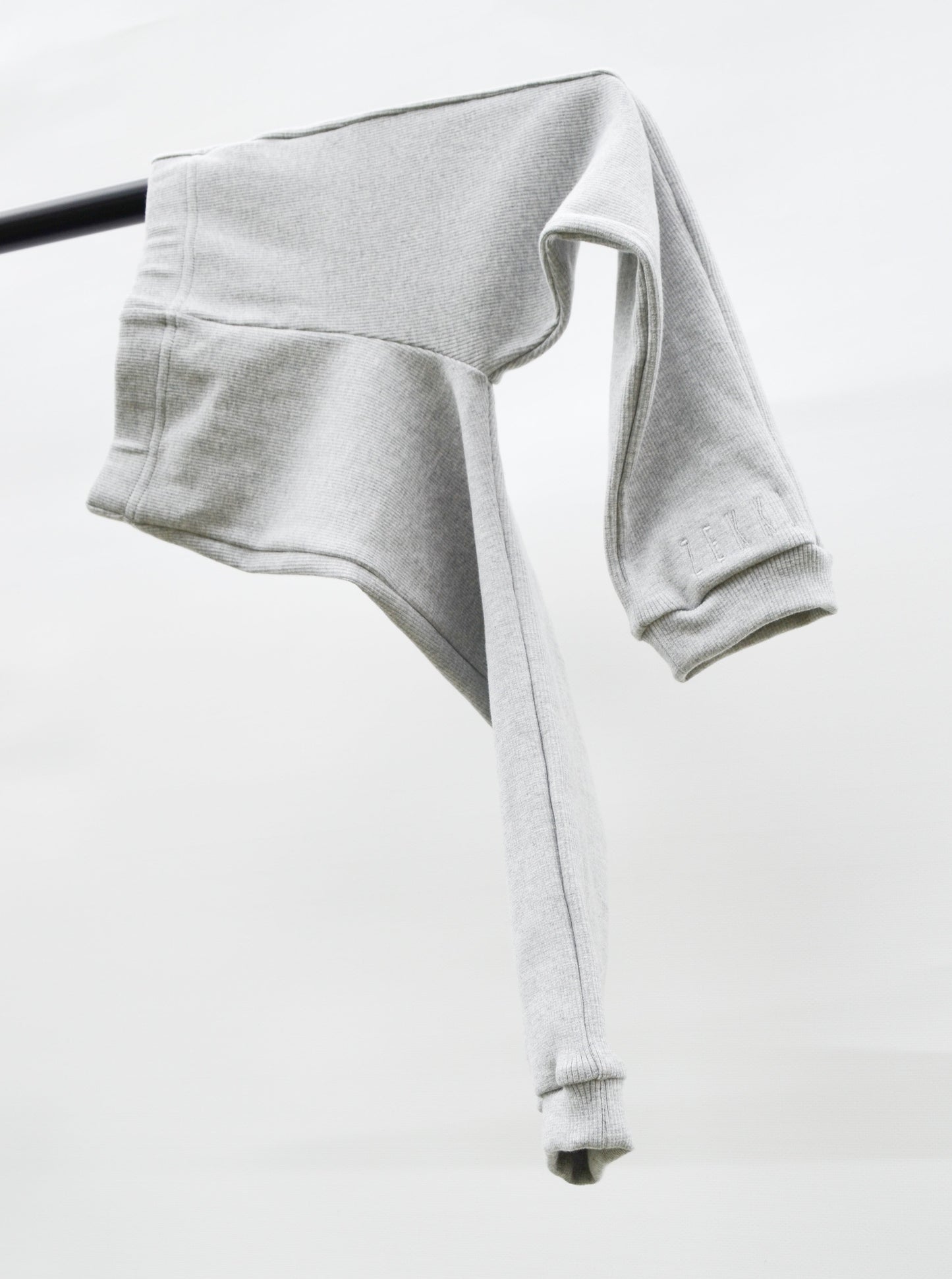 Grey casual pants hanging over pole