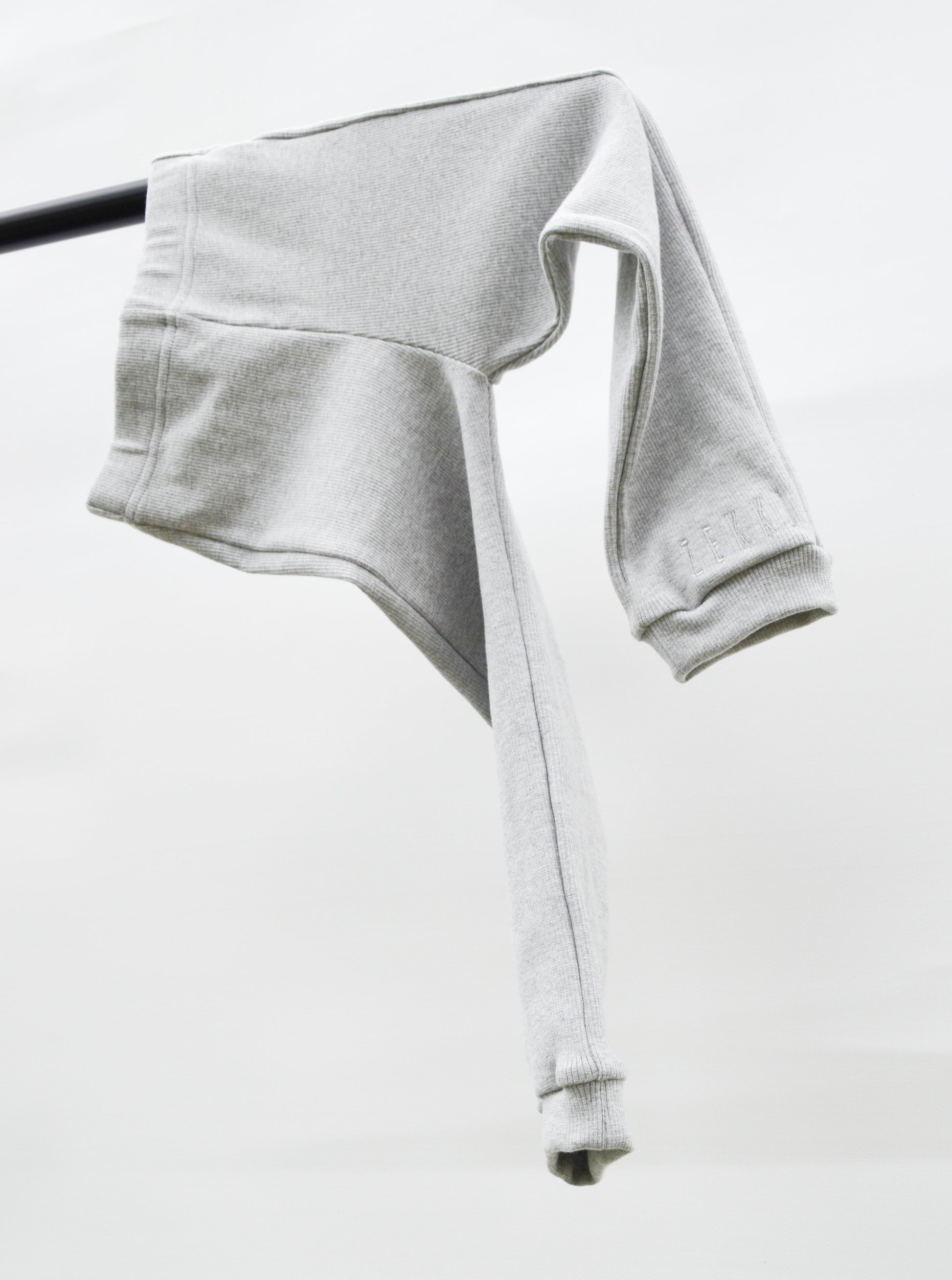 Grey casual pants hanging over pole