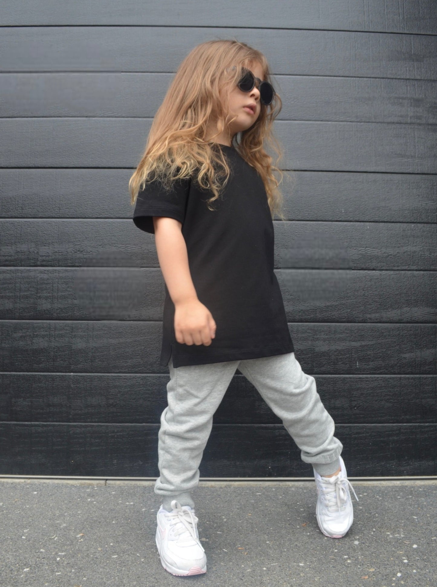Girl wearing black longline t-shirt and grey casual pants/leggings