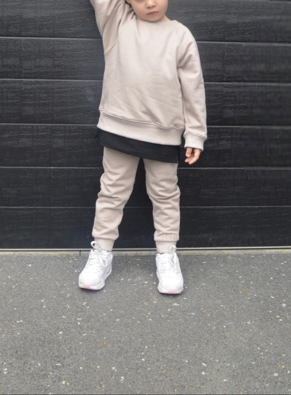 Girl wearing smokey colour batwing jumper with black longline t-shirt and smokey colour trackpants.